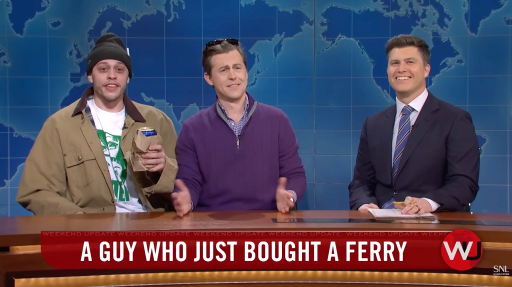 Pete Davidson, Alex Moffat, and Colin Jost sit at the SNL Weekend Update desk.