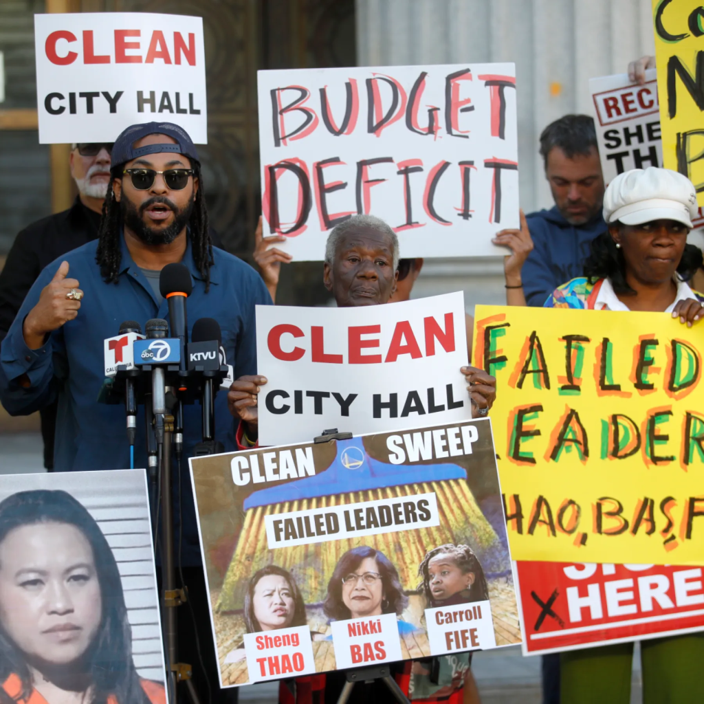 Seneca Scott and other protestors holding signs demanding to "Clean City Hall" due to "Budget Deficit" and "Failed Leaders".