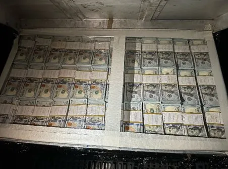 Bundles of hundred-dollar bills filling two compartments.