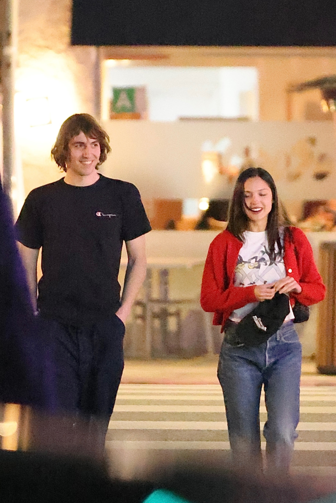 Olivia Rodrigo and Cameron Winter walking together on a street at night.