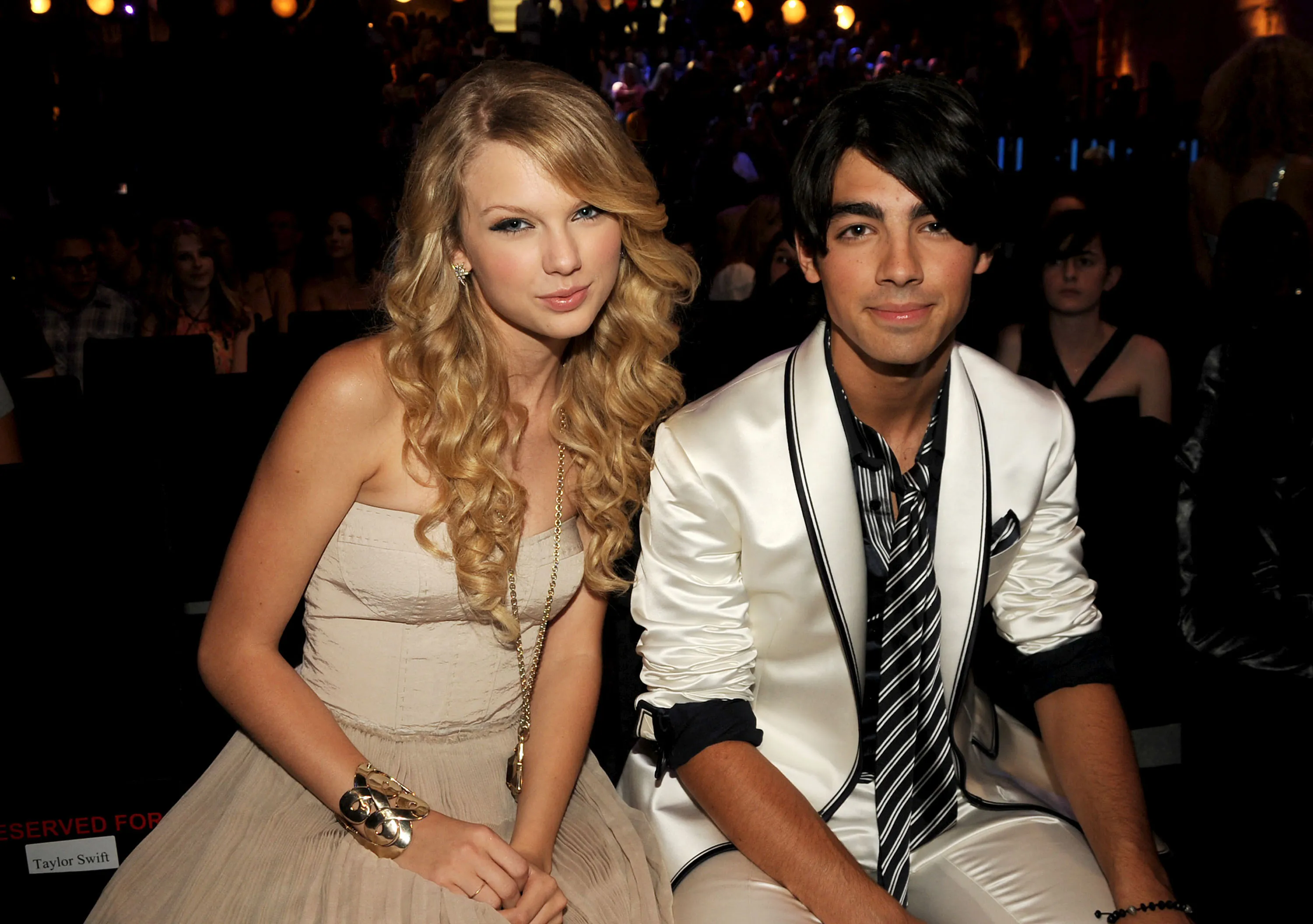 Taylor Swift and Joe Jonas sitting together in an audience at the 2008 MTV Video Music Awards.