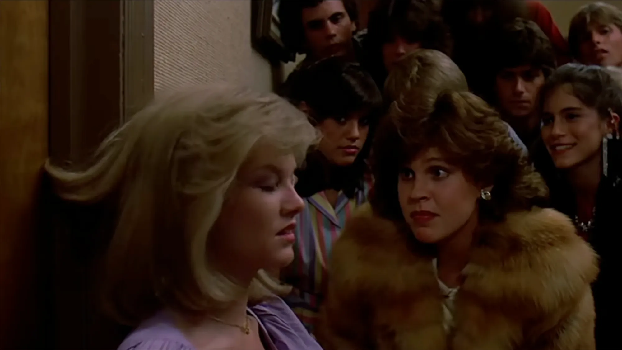 Jami Gertz as Robin and other young people on a staircase in "Sixteen Candles."