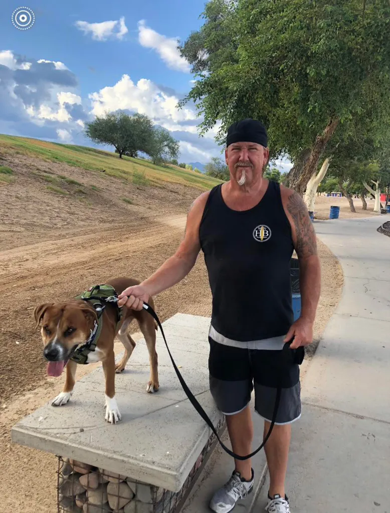 Darrell Sheets walking his dog on a leash.
