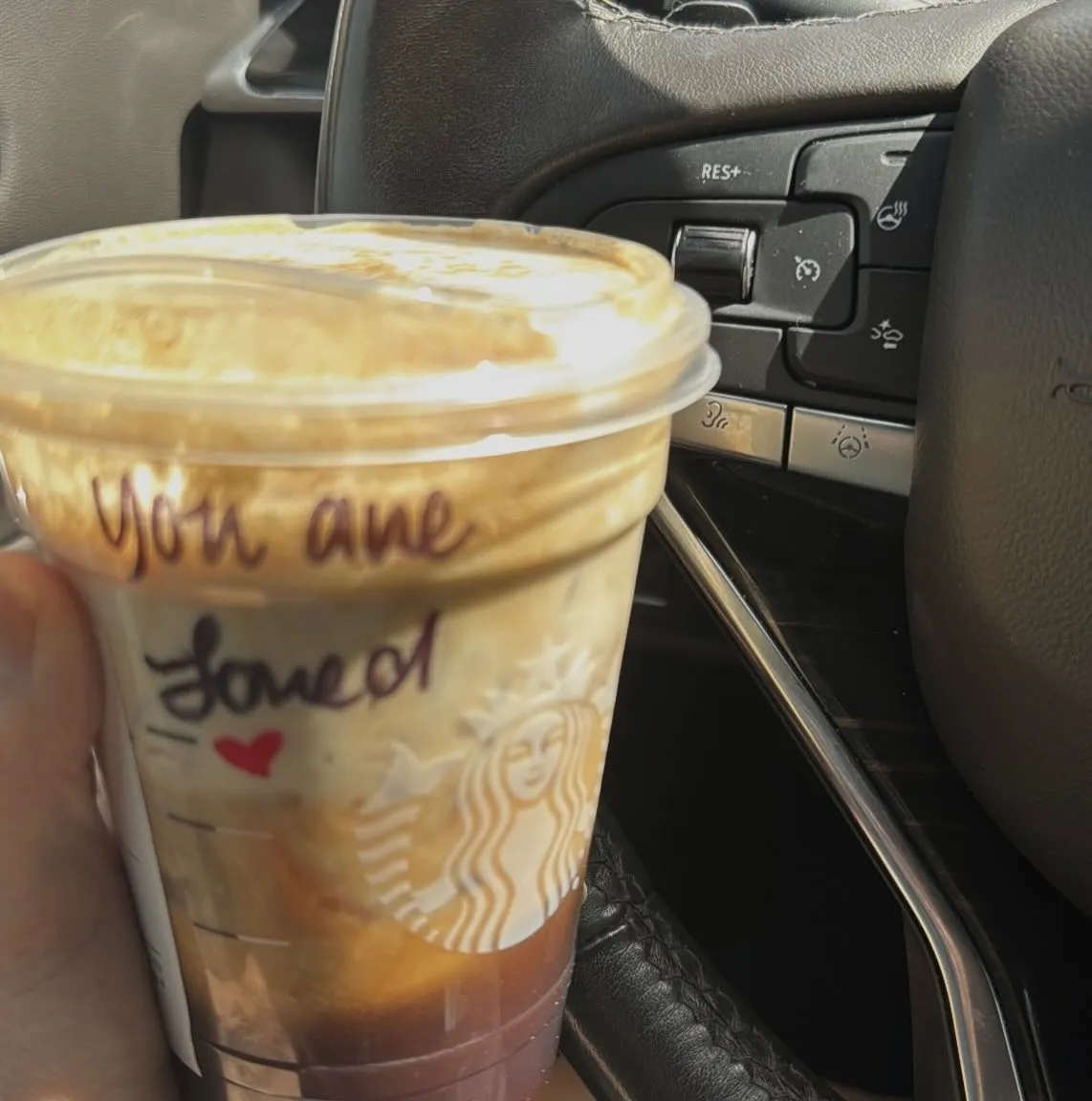 A Starbucks iced coffee drink with "You are loved" written on the cup.