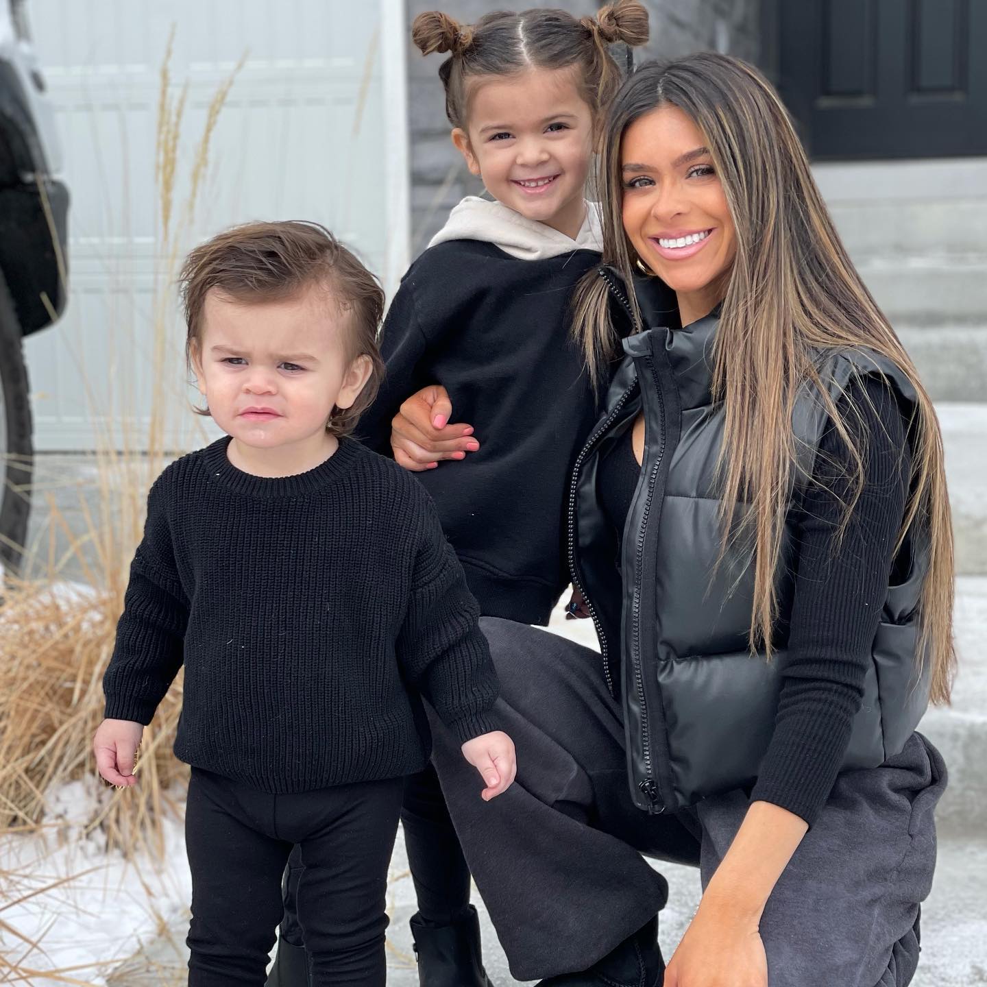 Taylor Frankie Paul kneeling with her two children in the snow.