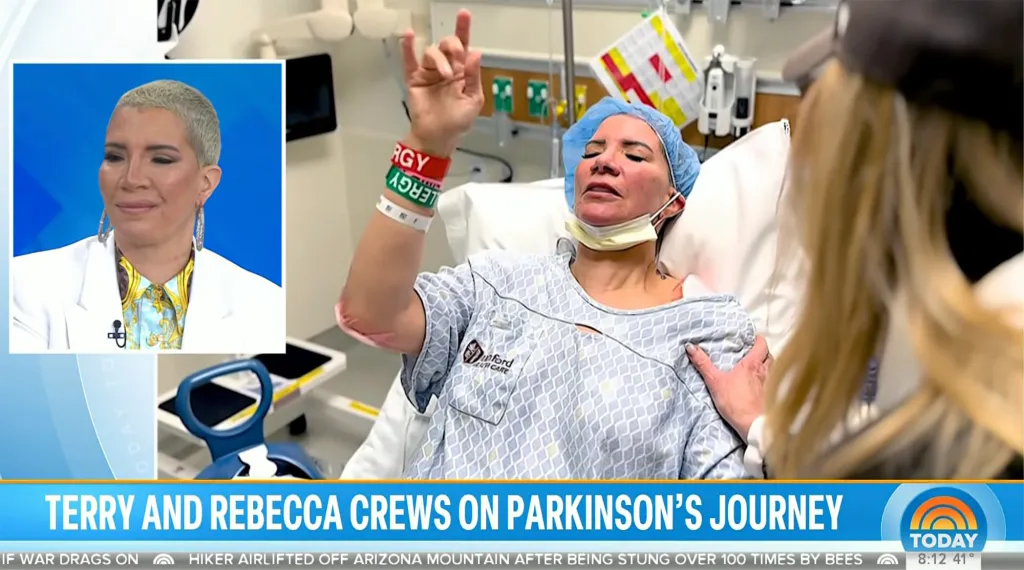 A woman in a hospital gown and surgical cap lies in a hospital bed, lifting her hand with wristbands, while another woman leans over her. A smaller inset image shows a smiling woman with short, light hair wearing a white blazer.