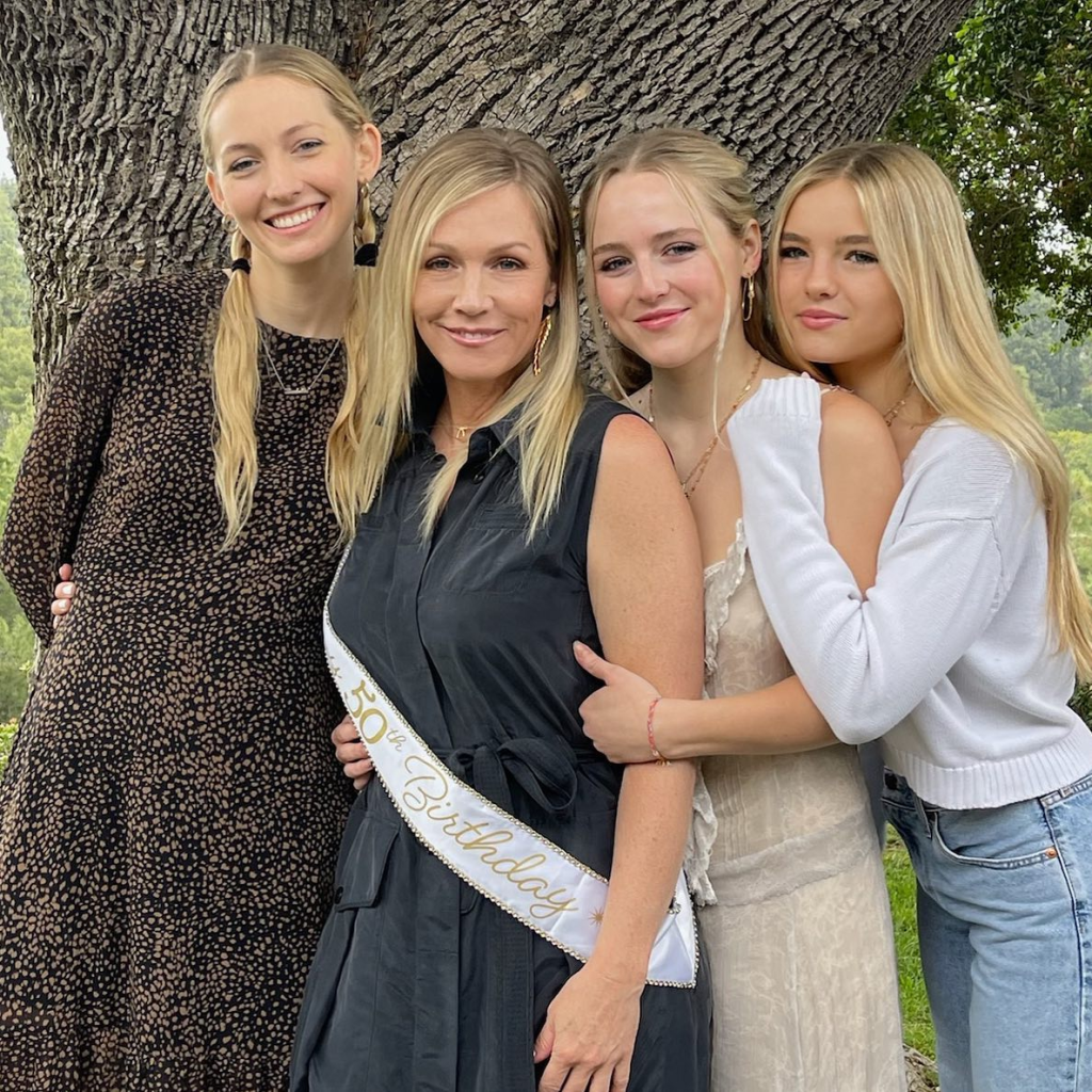 Jennie Garth. in a black dress, with her daughters Luca, in a black pattered dress, Fiona, in a cream dress, and Lola in a cream cardigan.