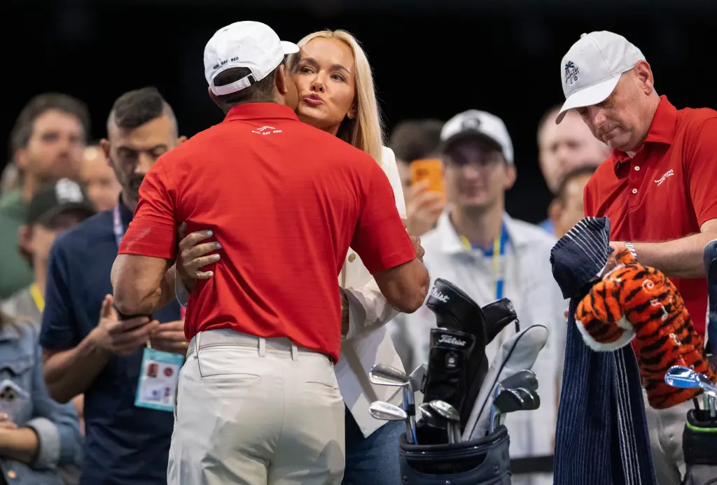 Vanessa Trump gives Tiger Woods a hug and kiss.