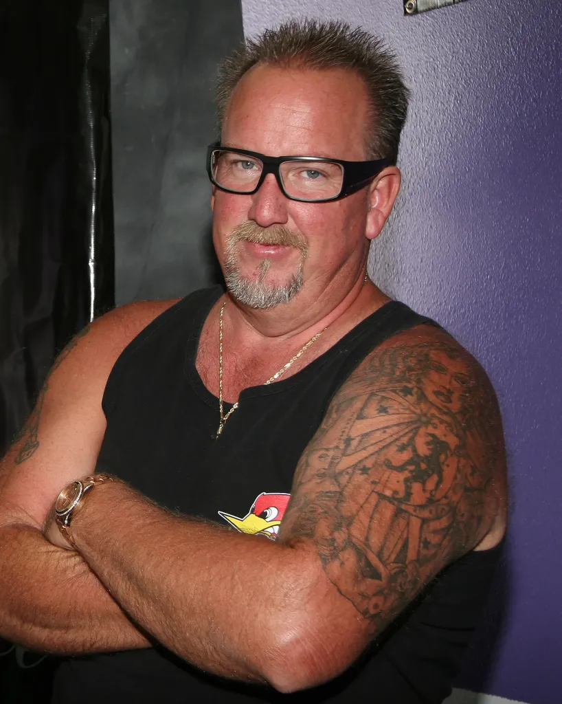 Darrell Sheets, a TV personality from Storage Wars, wearing a black tank top and glasses.