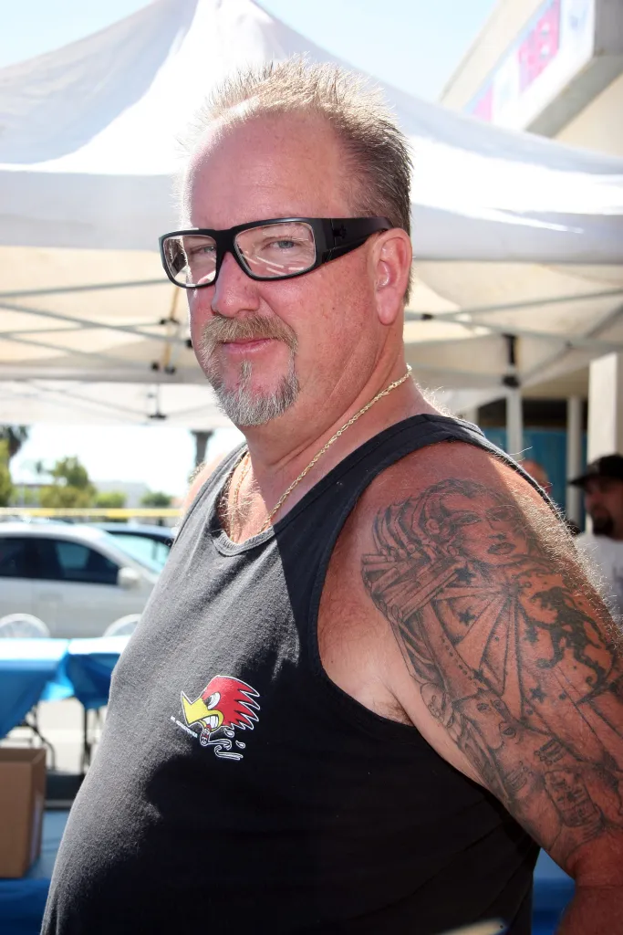 Darrell Sheets from "Storage Wars" wearing glasses, a tank top, and a gold chain.