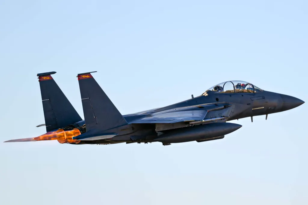 An F-15E takes off with afterburners ablaze.