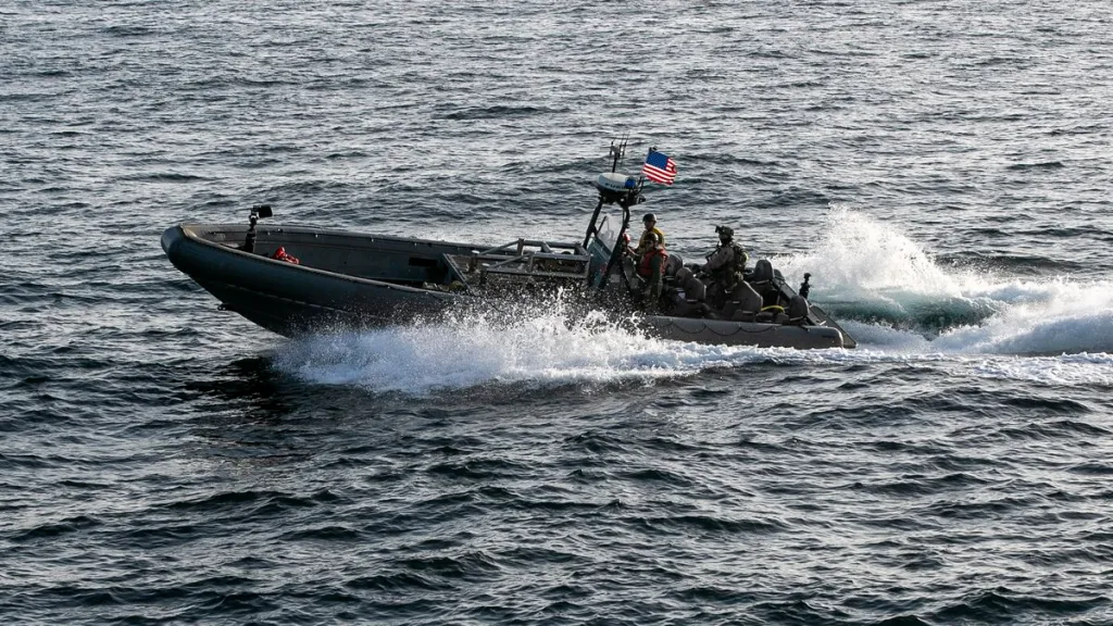US forces patrol the Arabian Sea aboard a boat with an American flag.