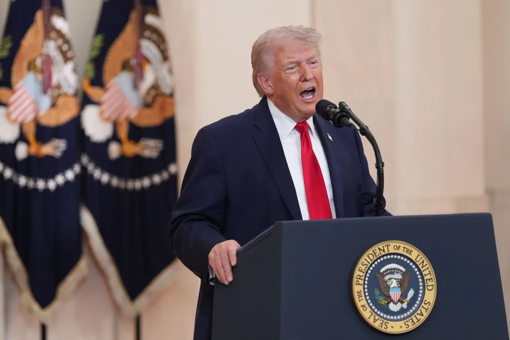 Donald Trump speaking at a podium with a microphone.