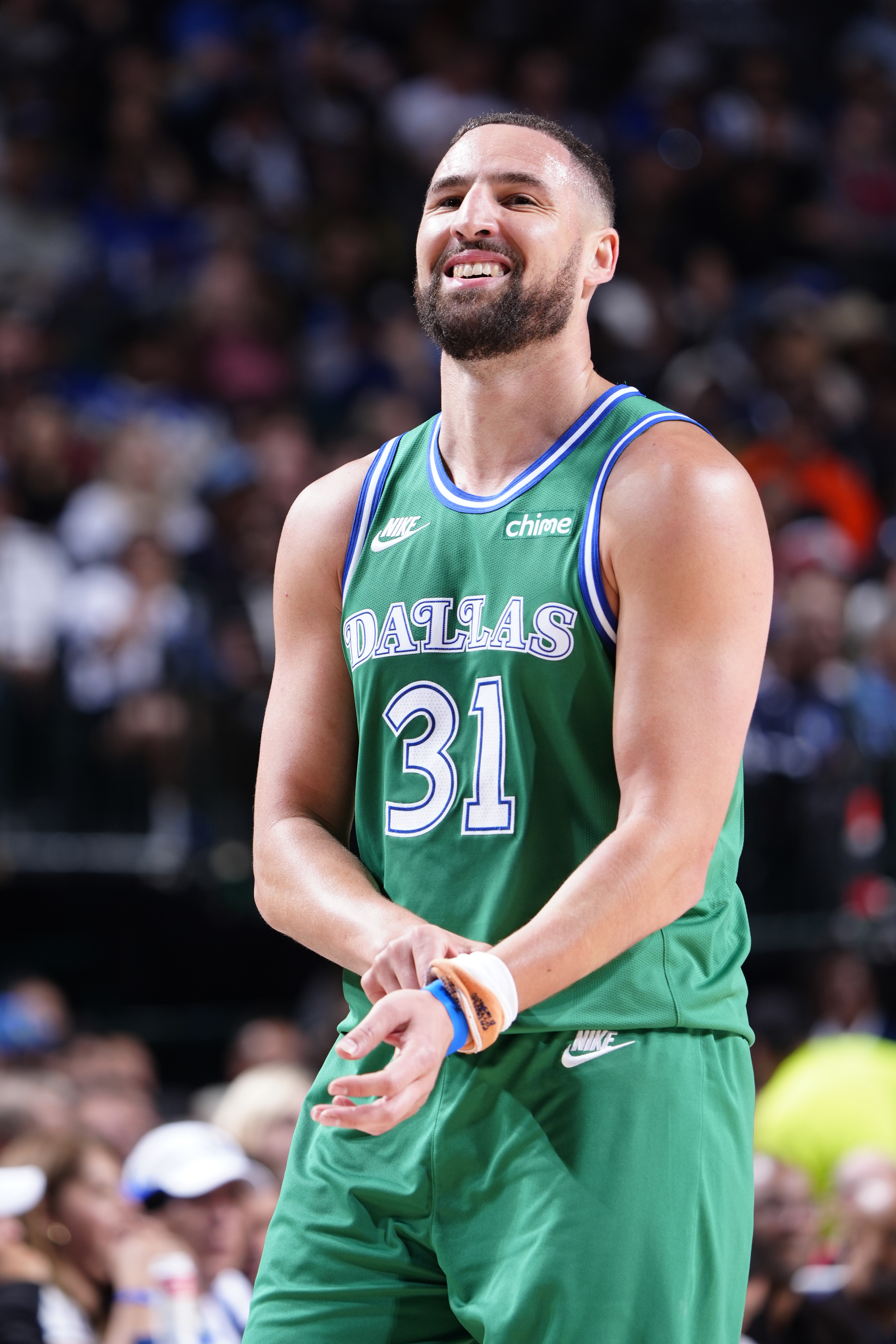 Klay Thompson smiling in a Dallas Mavericks uniform.