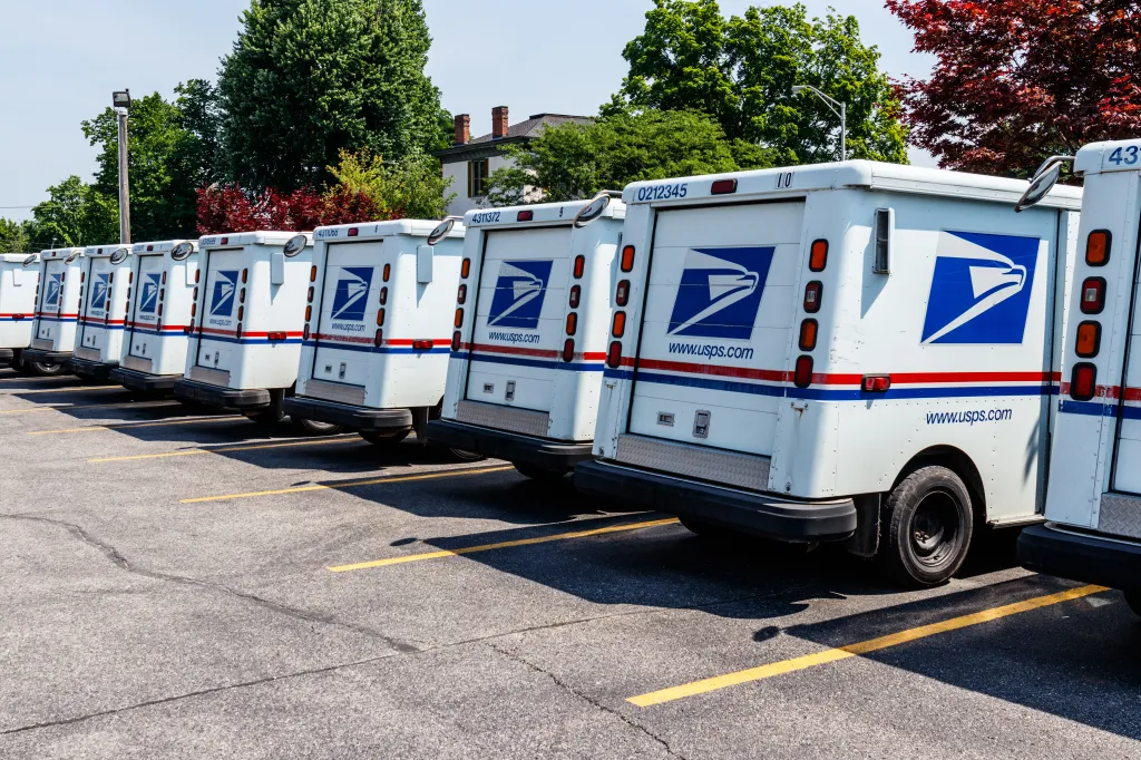USPS mail trucks parked in a row.