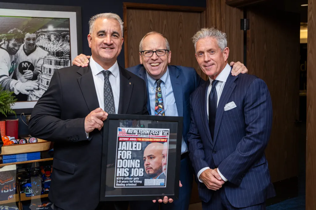 Vincent Vallelong, John Ledecky, and Pat Judge posing with a framed New York Post newspaper with the headline "Jailed For Doing His Job".