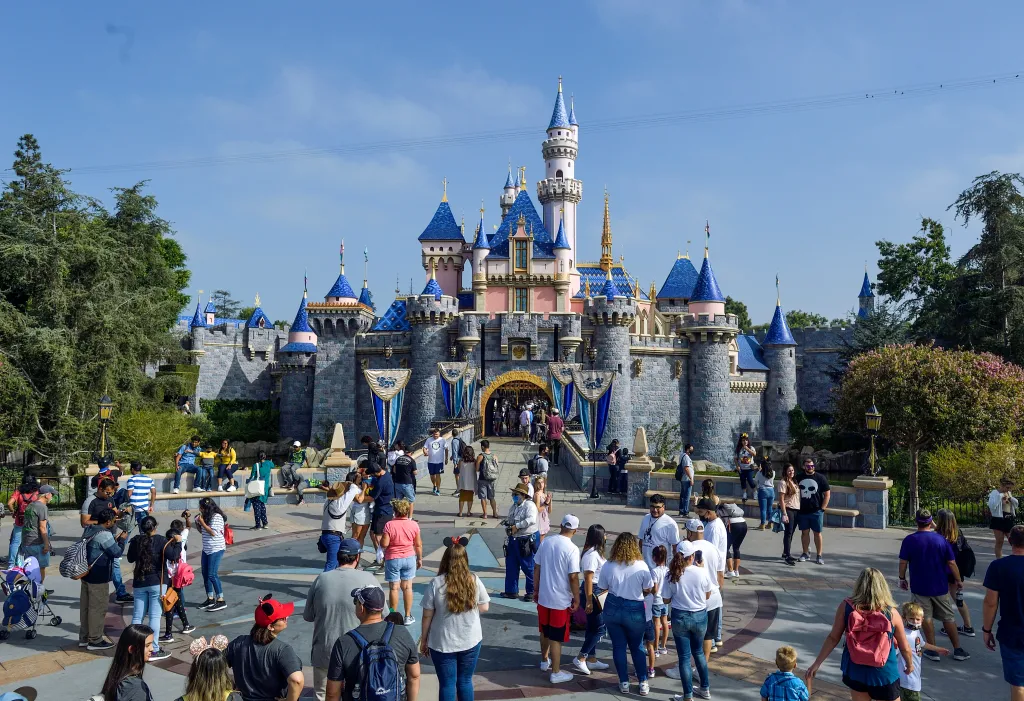 Visitors in front of Sleeping Beauty Castle at Disneyland.