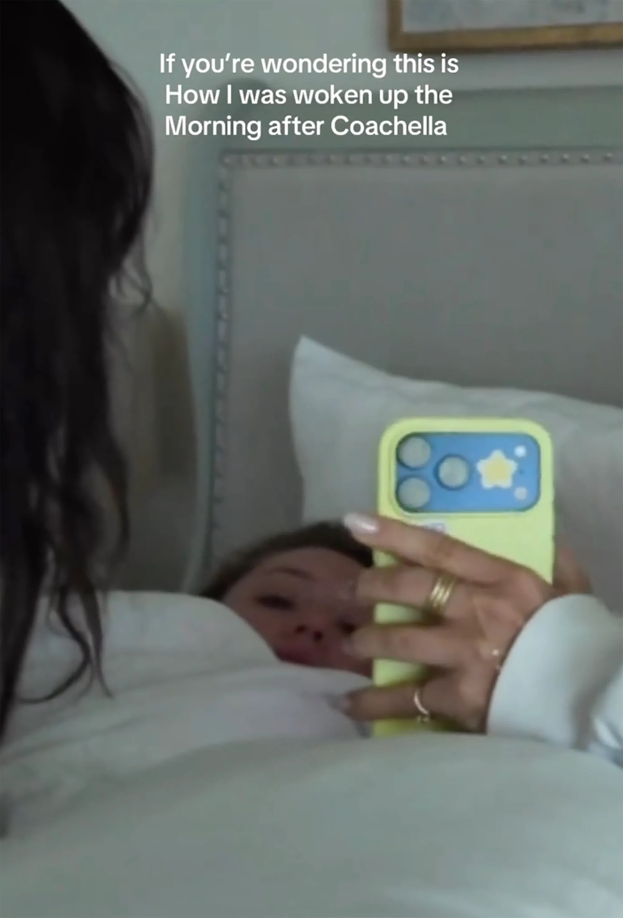 A person with long dark hair lying in bed, peeking over a white blanket at their phone. Text over the image reads, 