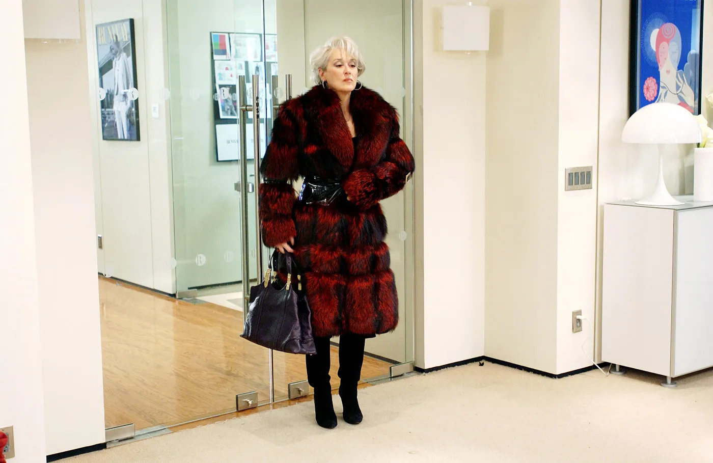 Meryl Streep as an editor in chief, wearing a fur coat and carrying a handbag.