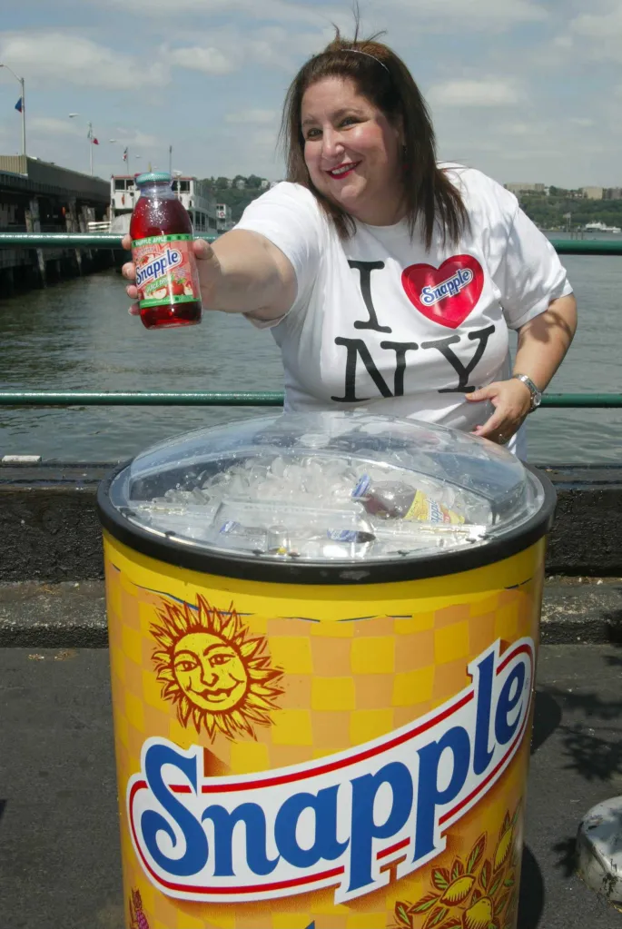 Wendy Kaufman, "The Snapple Lady," holding a bottle of Snapple Apple juice drink.