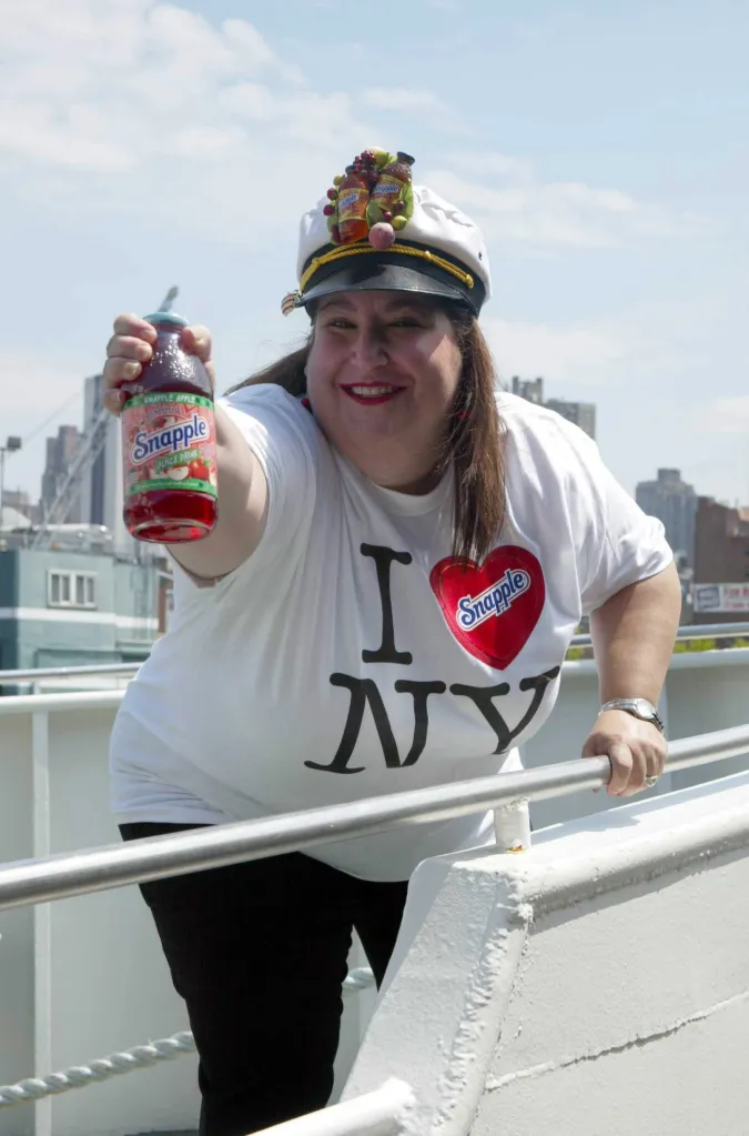 Wendy Kaufman holding a Snapple Apple juice drink, wearing an 