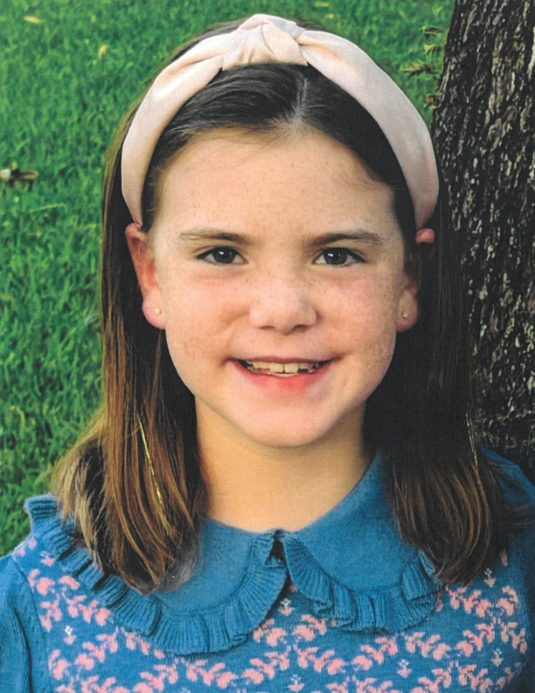 Portrait of Ellen Getten, a young girl with a light pink knotted headband and a blue sweater with a ruffled collar.
