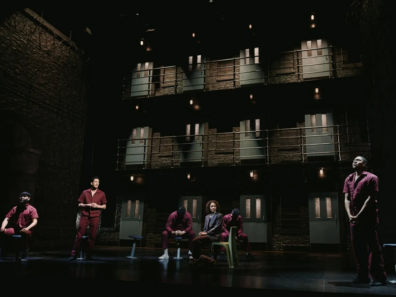 Stage set for a play about a man who spent over 20 years on Death Row, featuring actors in a prison cell block setting.