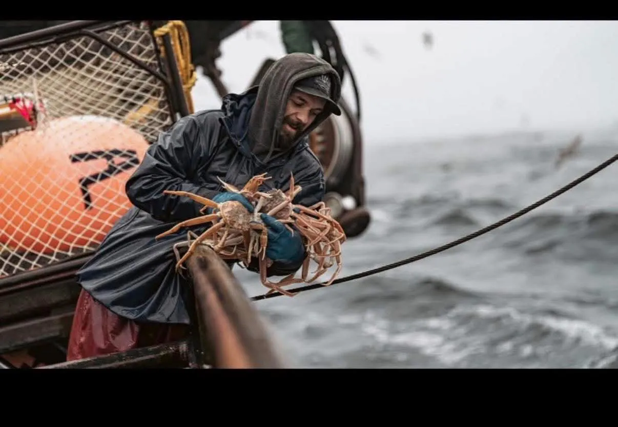 Todd Meadows holding a pile of crabs on a boat.
