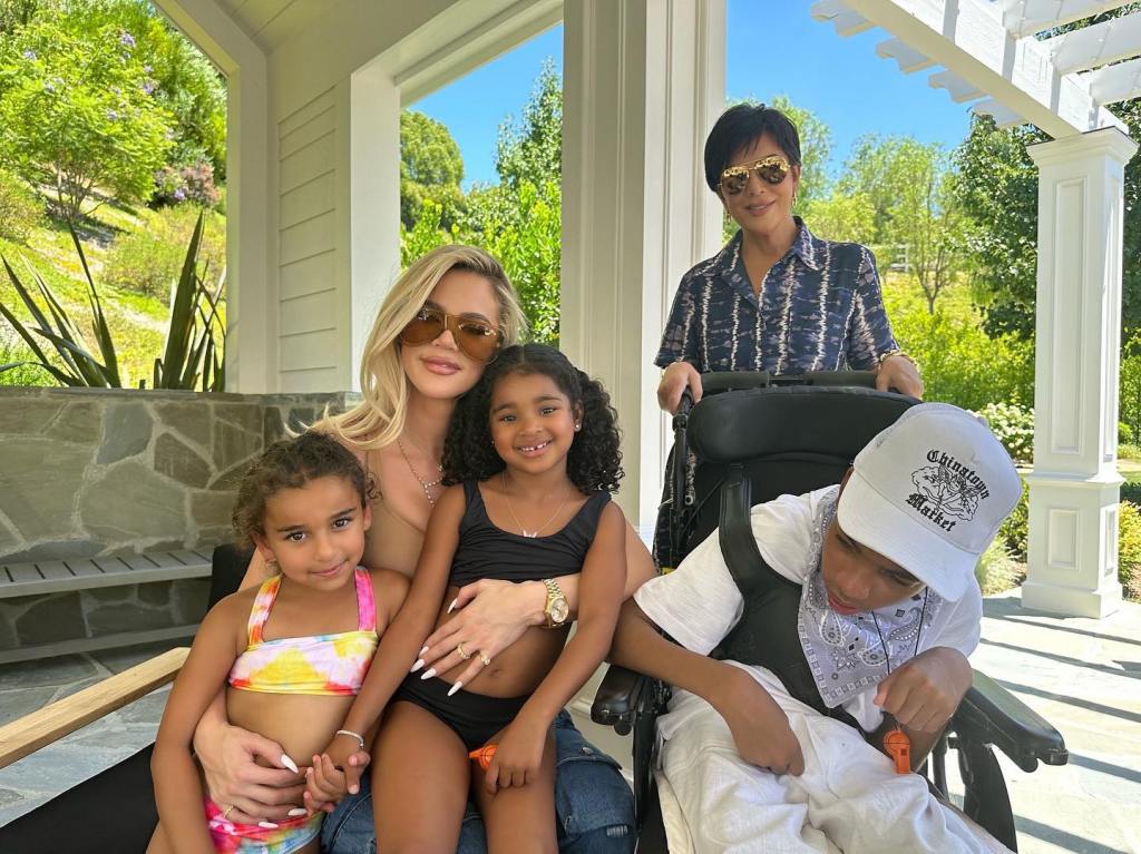 Khloe Kardashian with Tristan Thompson's brother Amari and two girls, pushed in a wheelchair by Kris Jenner.