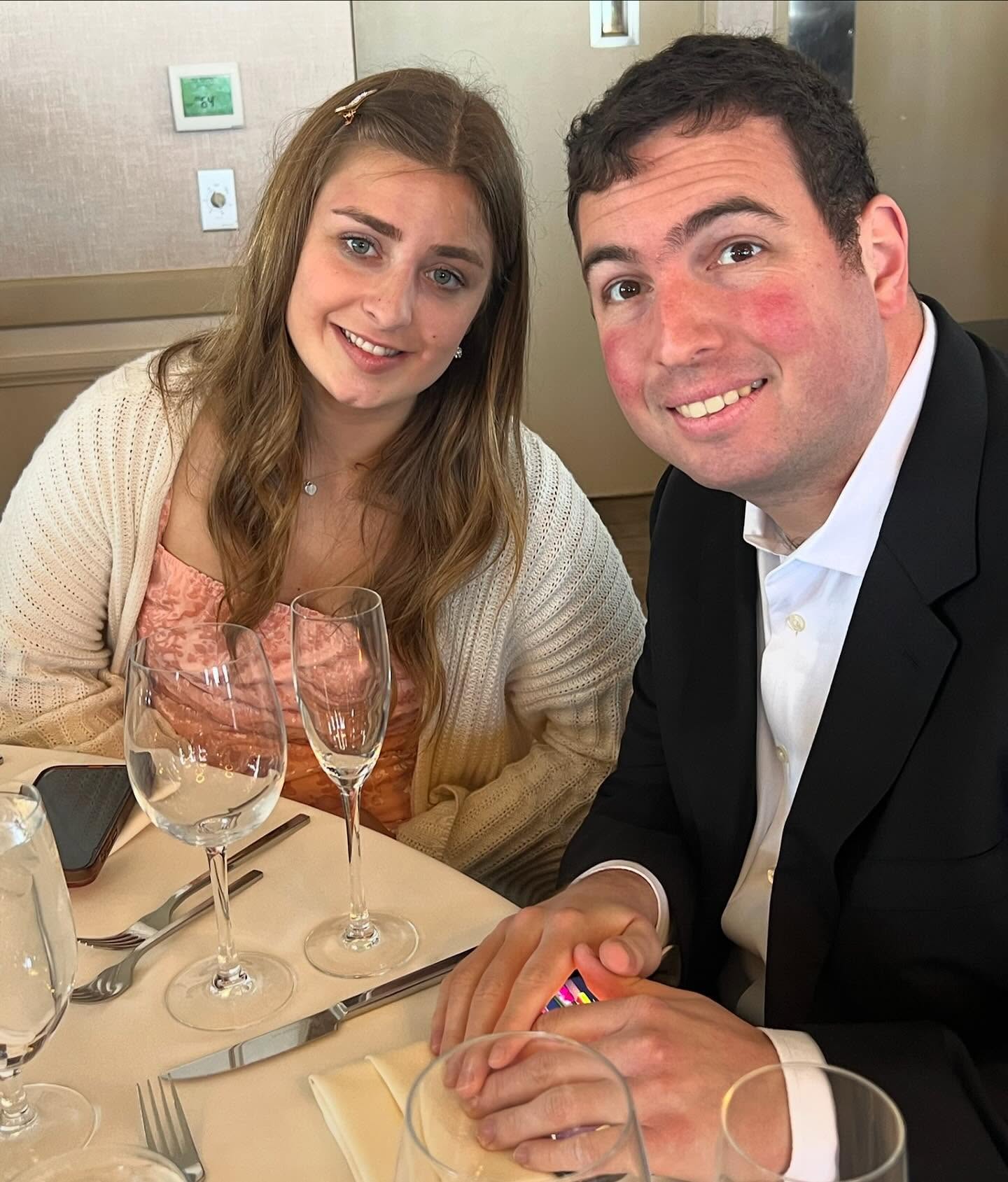 Abbey Romeo and David Isaacman smiling at a restaurant table.