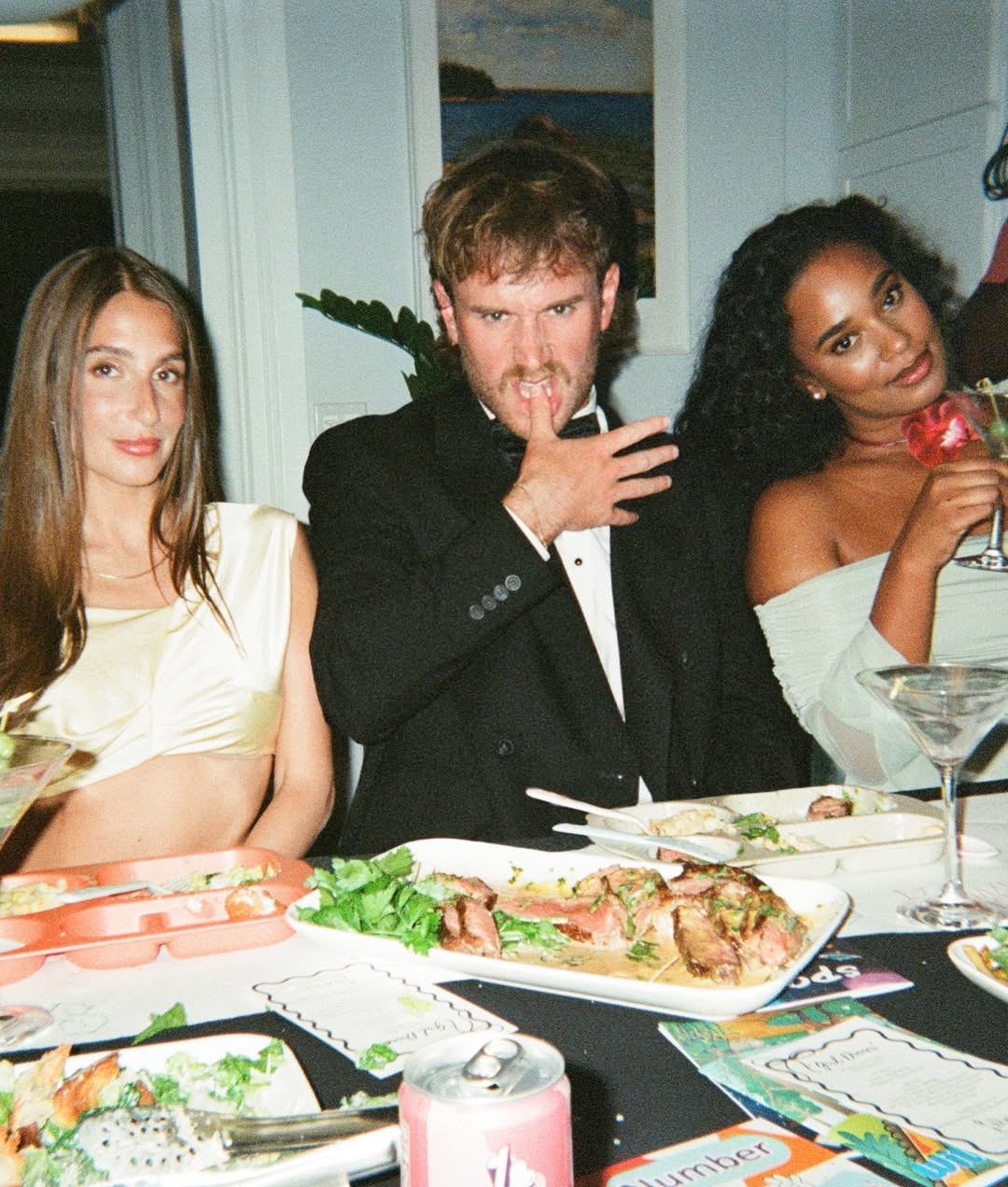 West Wilson and Amanda Batula with a friend at a table.