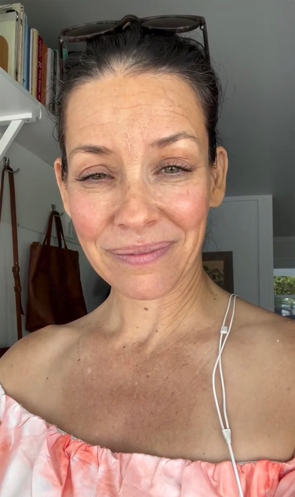Evangeline Lilly in an off-the-shoulder top, smiling faintly.