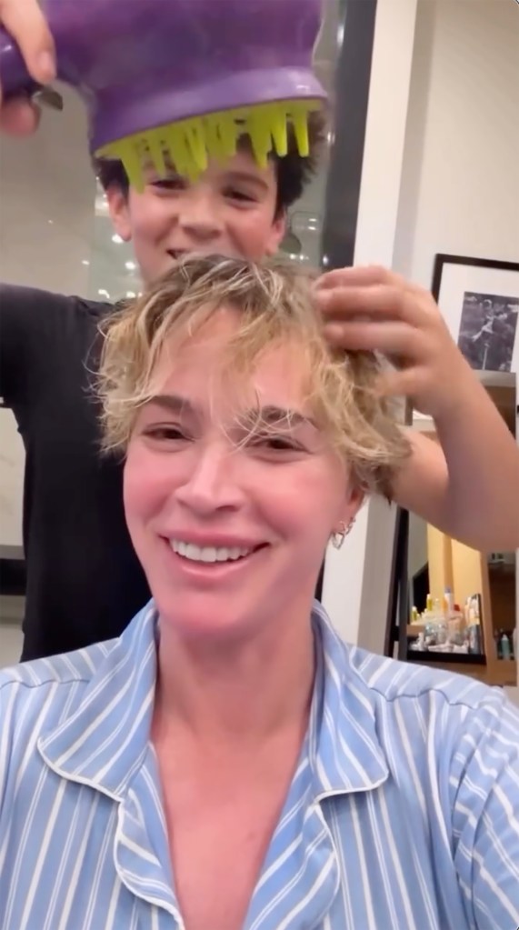 Teddi Mellencamp getting her hair styled by a young boy using a purple hair diffuser.