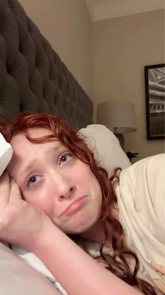 Chappell Roan lying in bed looking sad.