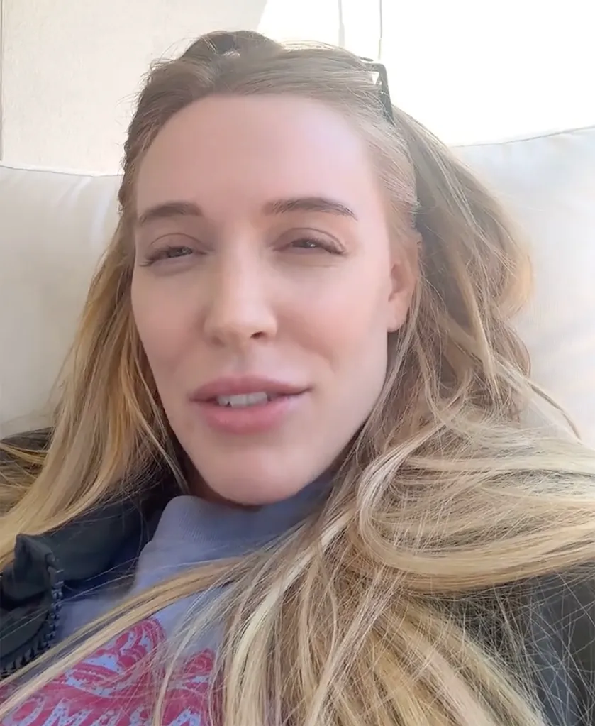 A woman with long blonde hair and a casual top looks directly at the viewer.