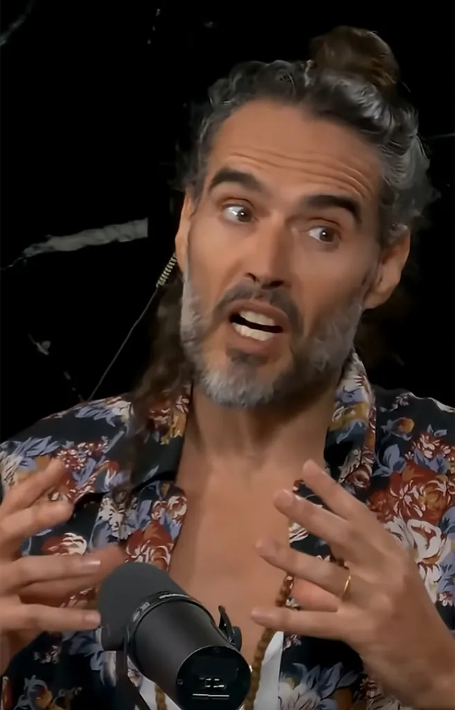 Russell Brand speaking into a microphone.