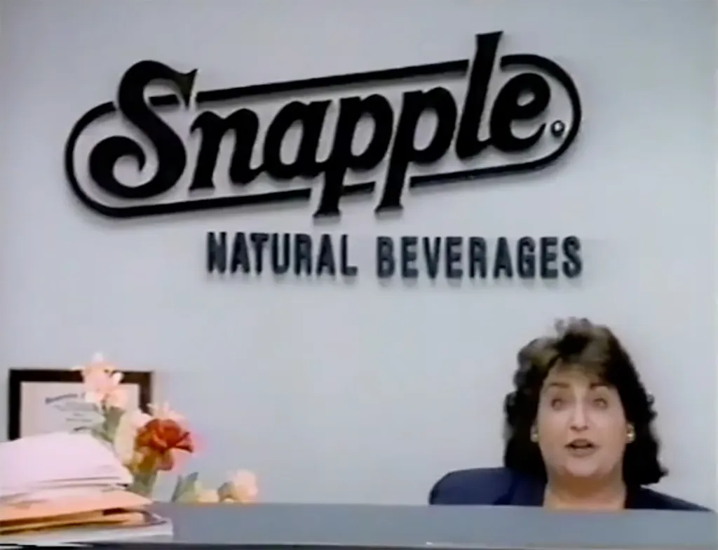 Wendy Kaufman, spokesperson for Snapple, in front of a "Snapple Natural Beverages" sign.