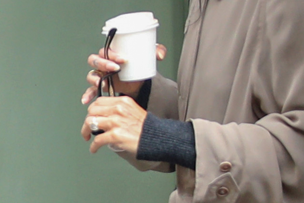 Zoe Kravitz holding a takeaway coffee cup, with a diamond ring on her left hand.
