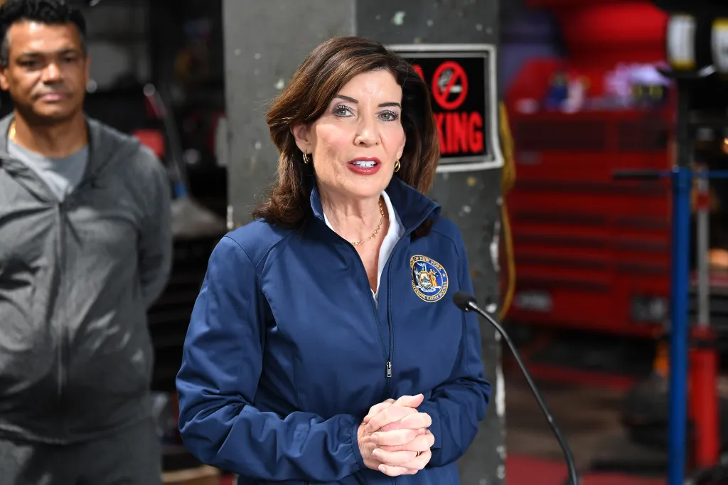Kathy Hochul speaks at a gas station/garage to announce a bill to reduce auto insurance costs for New Yorkers.