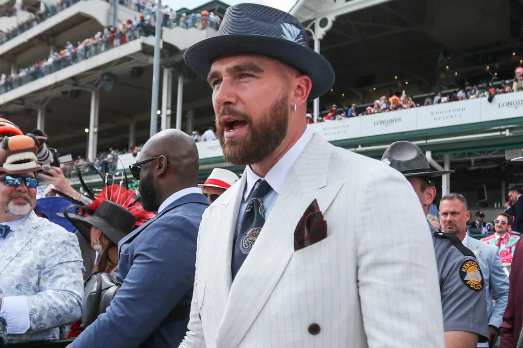 Travis Kelce in a pinstripe suit and fedora with his mouth open at the Kentucky Derby.