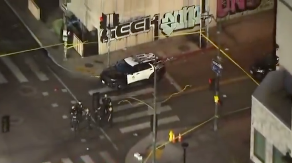 An aerial view of a police investigation at a street intersection at night.