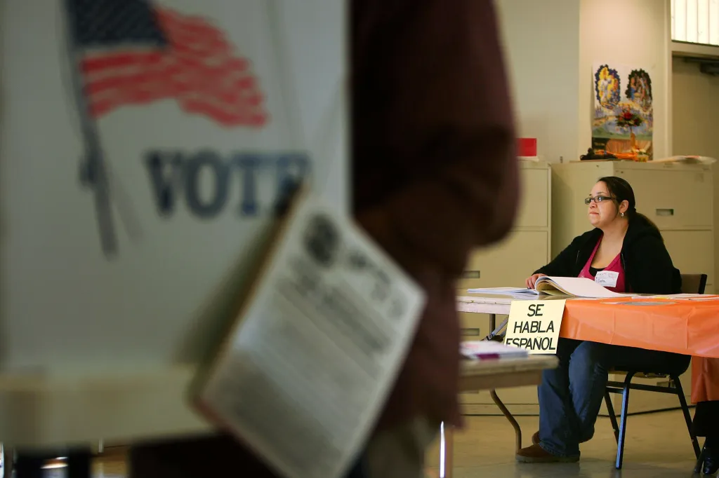 A woman election official at a table with a "Se habla Espanol" sign at a Super Tuesday primary election in Los Angeles.