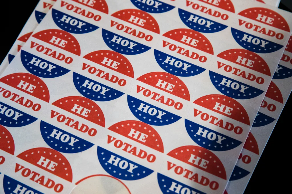 Sheets of "He Votado Hoy" stickers, meaning "I Voted Today" in Spanish, with red and blue designs.