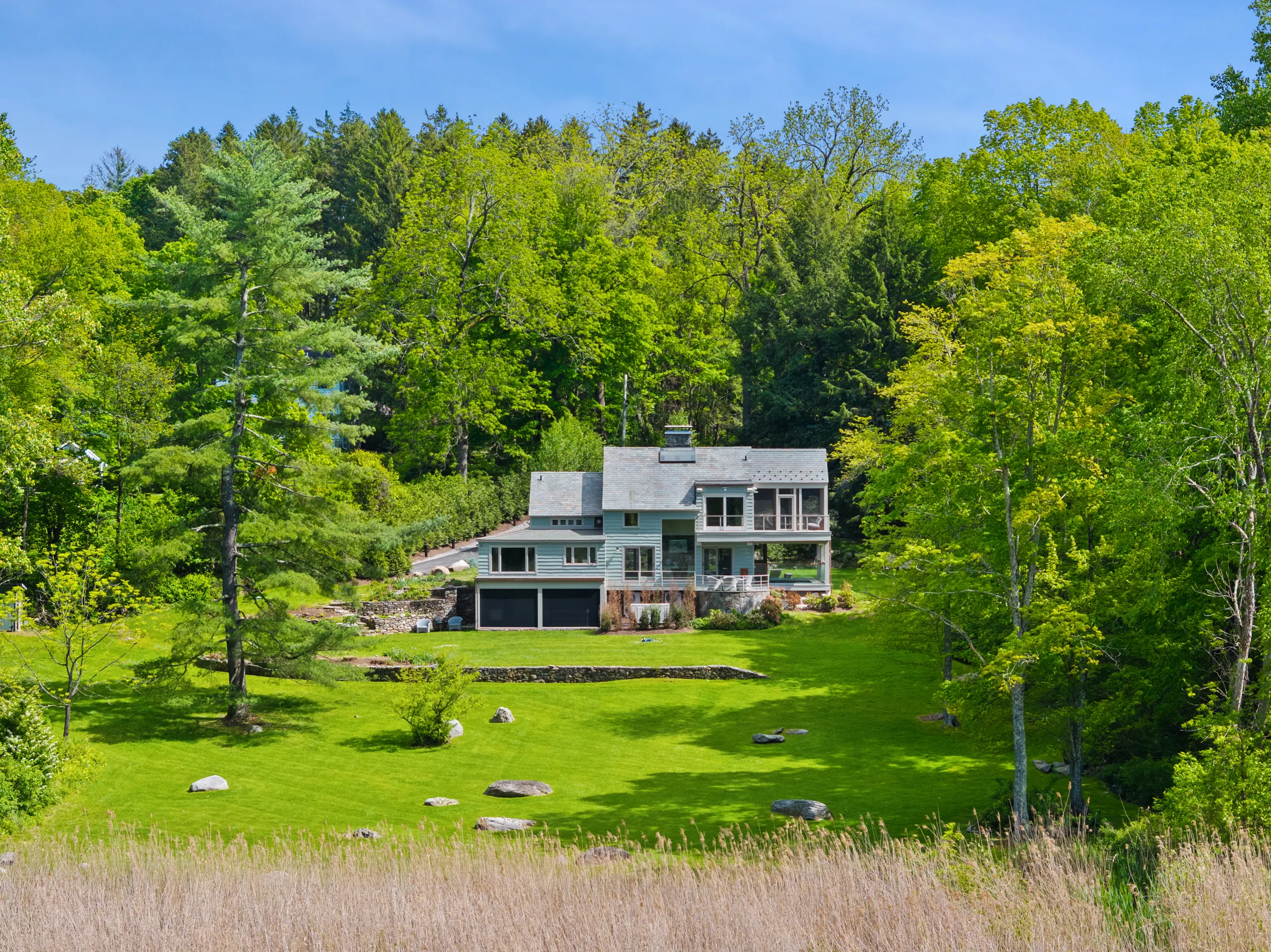 Pete Davidson's former North Salem, Westchester home sits on a hill, surrounded by trees and a green lawn.