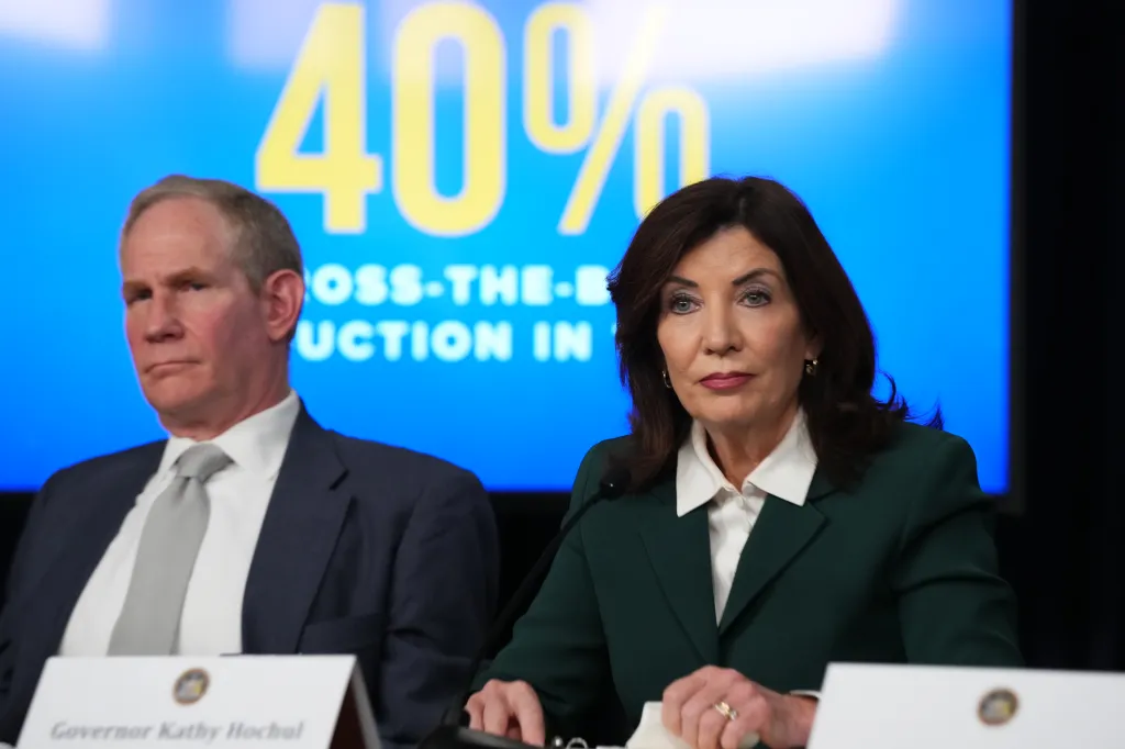 New York Governor Kathy Hochul and MTA CEO Janno Lieber at a news conference about congestion pricing, with a "40%" sign in the background.