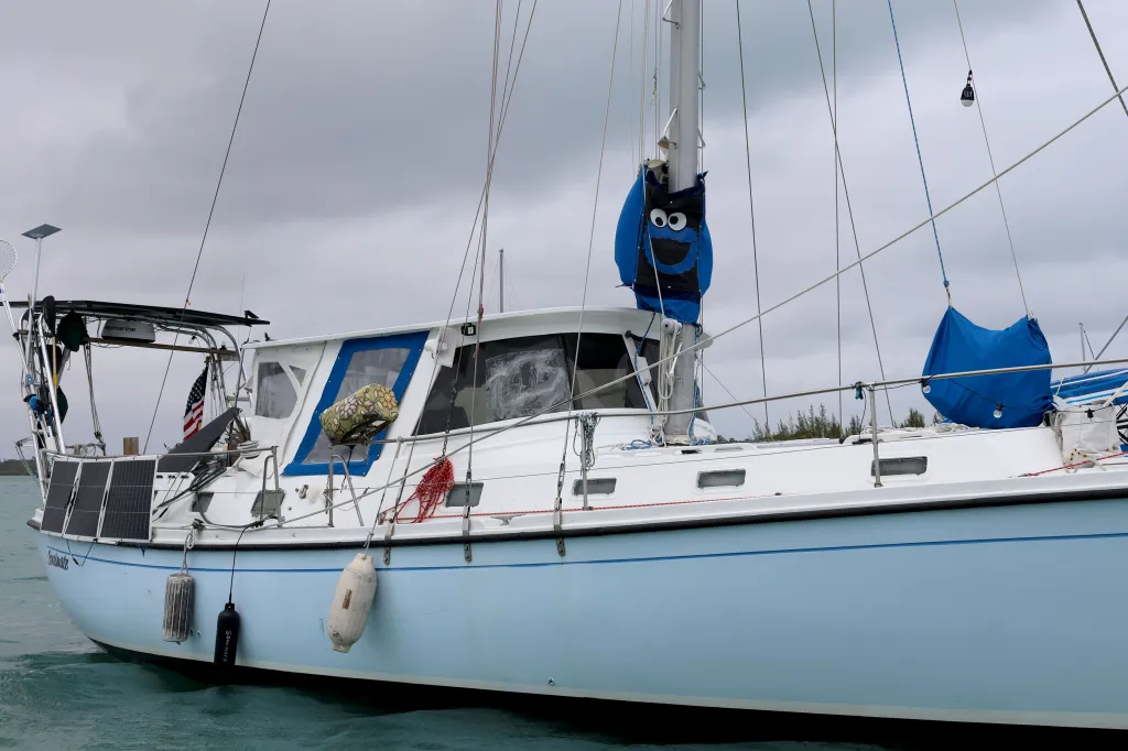 The boat "Soulmate" with solar panels, fenders, and a blue Cookie Monster sail cover.