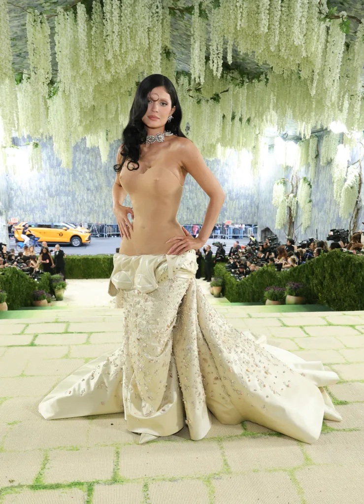 Kylie Jenner in a sheer, strapless, nude-colored top and an embellished, cream-colored satin skirt at the 2026 Met Gala.