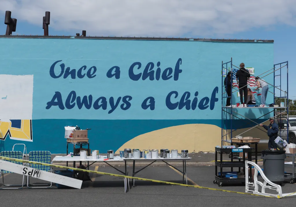 Students from Massapequa High School paint a mural that reads, "Once a Chief, Always a Chief."