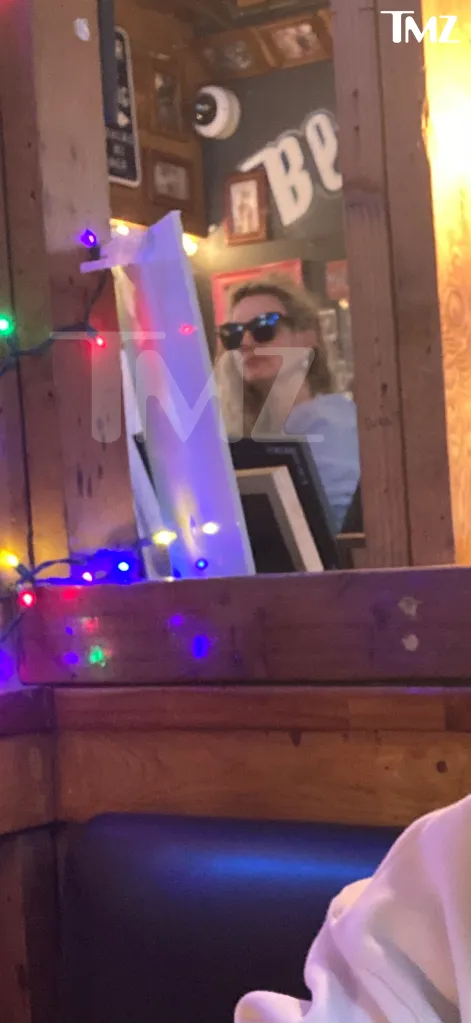 Britney Spears wearing sunglasses in a restaurant.