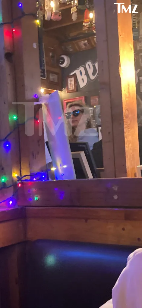 Britney Spears wearing sunglasses in a restaurant.